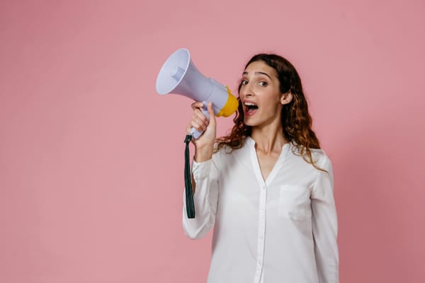 Woman holding broadcast mike and speaking on it